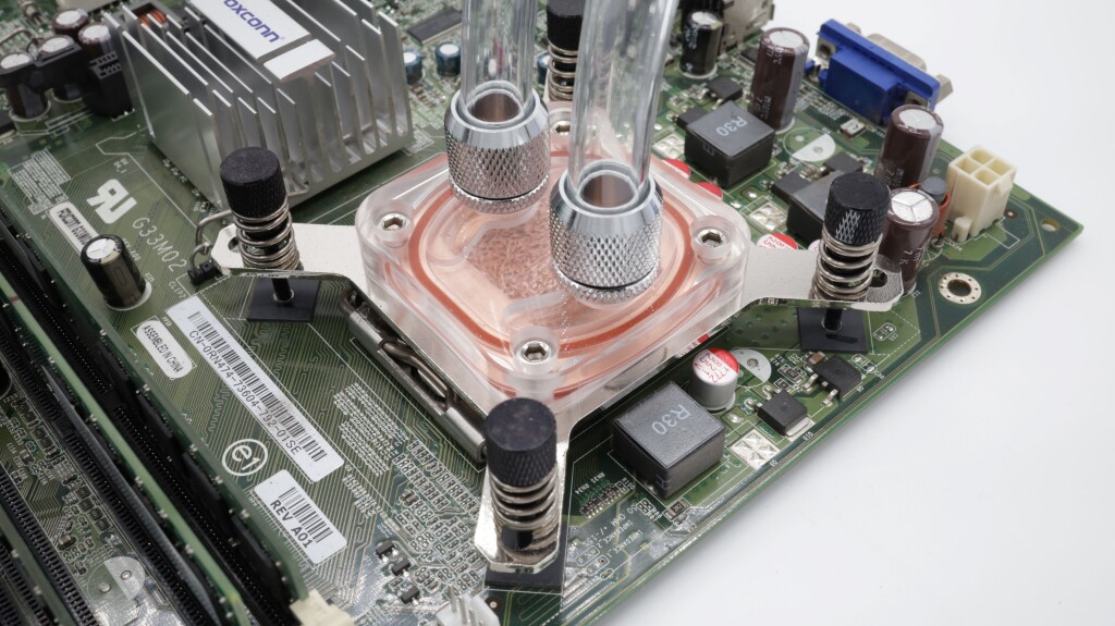 Photo of a copper cold plate with a clear lid attached to a PCB