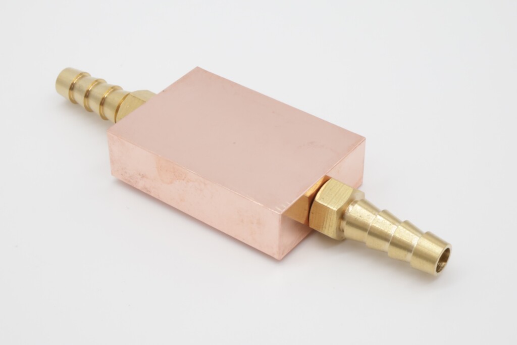 Photo of a copper cold plate with barbed fittings